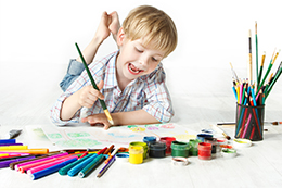 Uśmiechnięte dziecko maluje farbkami